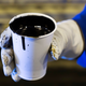 A worker holds a cup of heavy oil before it is shipped to the market south of Fort McMurray, Alberta.